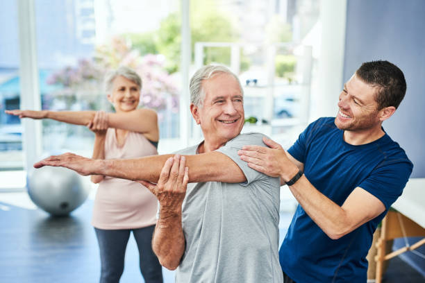 physiotherapist working with a senior couple in his chiropractic clinic
